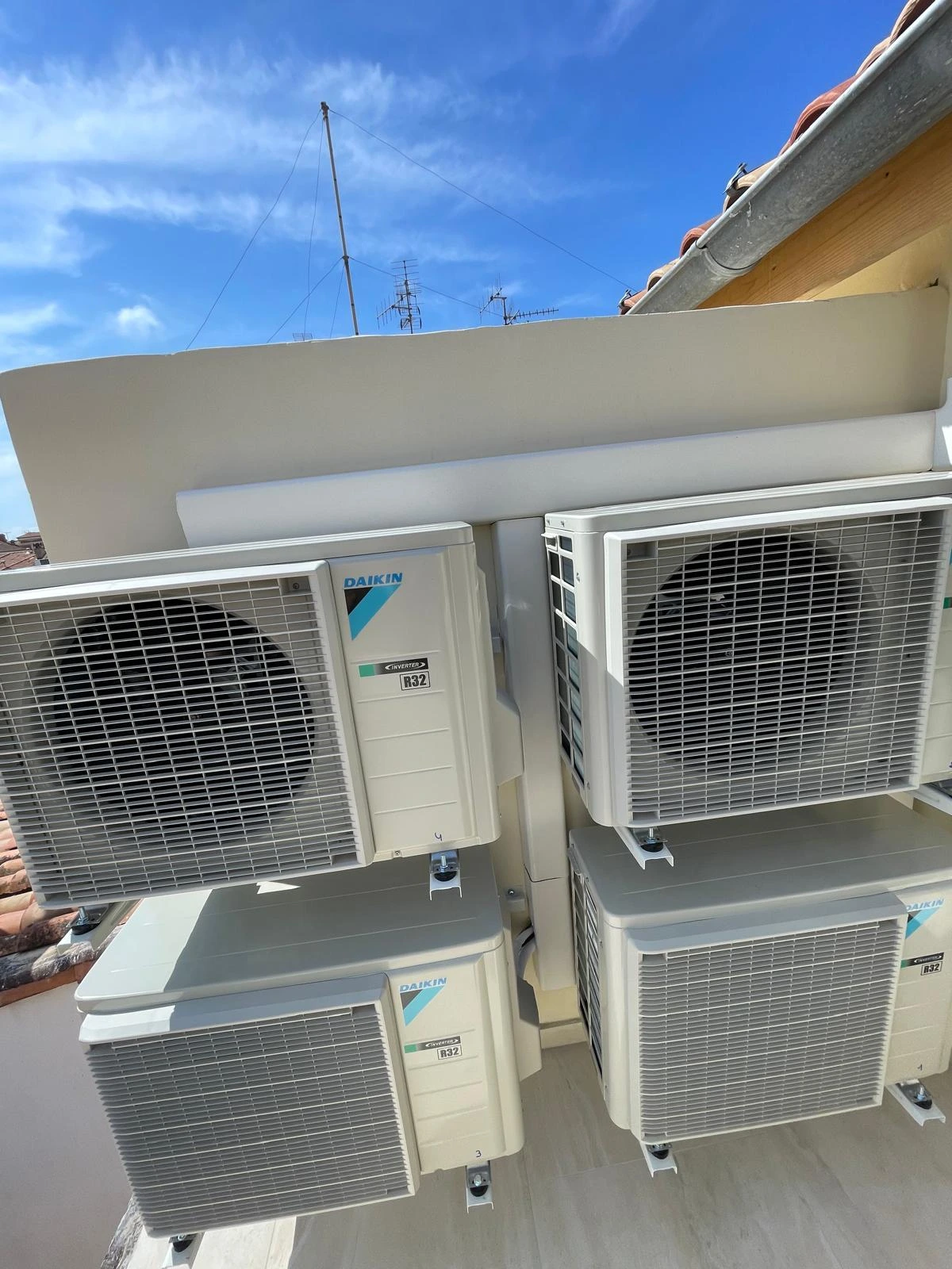 Différents modèles de climatiseurs muraux exposés au-dessus de vitrines contenant des outils techniques.